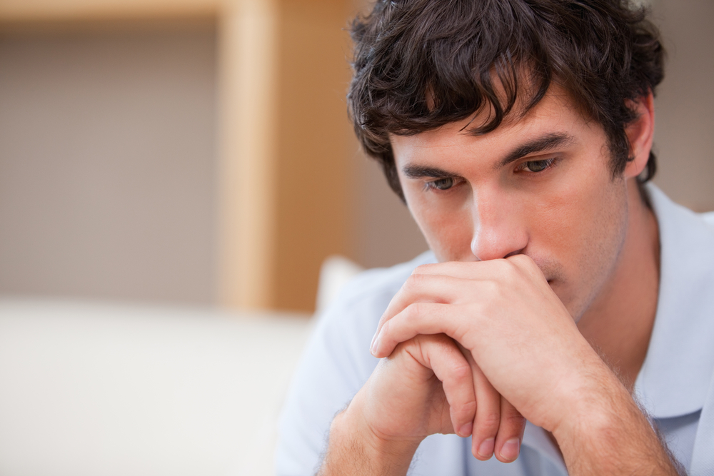 Thoughtful young man in the living room-1